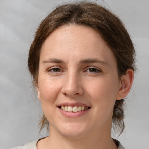 Joyful white young-adult female with medium  brown hair and grey eyes