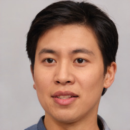 Joyful asian young-adult male with short  brown hair and brown eyes