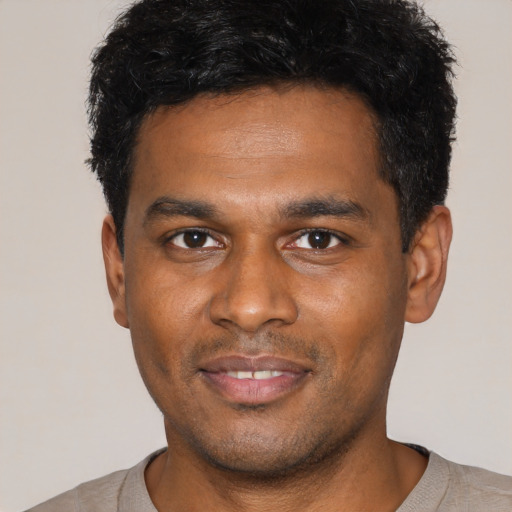 Joyful latino young-adult male with short  black hair and brown eyes