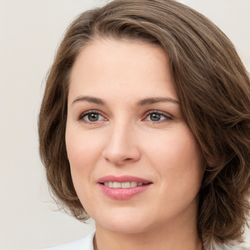 Joyful white young-adult female with medium  brown hair and green eyes