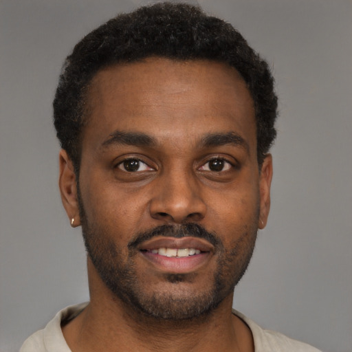 Joyful black young-adult male with short  brown hair and brown eyes