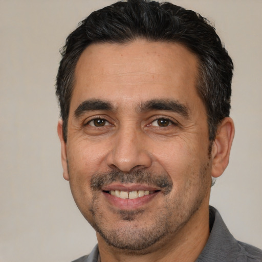 Joyful white adult male with short  black hair and brown eyes