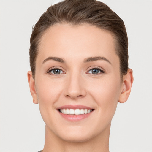 Joyful white young-adult female with short  brown hair and grey eyes