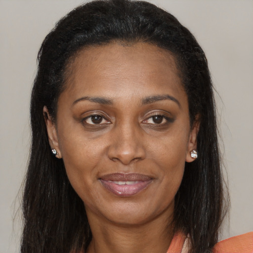 Joyful black adult female with long  brown hair and brown eyes