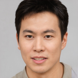 Joyful asian young-adult male with short  brown hair and brown eyes