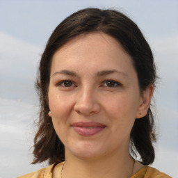 Joyful white young-adult female with medium  brown hair and brown eyes