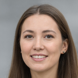 Joyful white young-adult female with long  brown hair and brown eyes