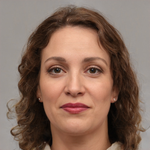 Joyful white adult female with medium  brown hair and green eyes