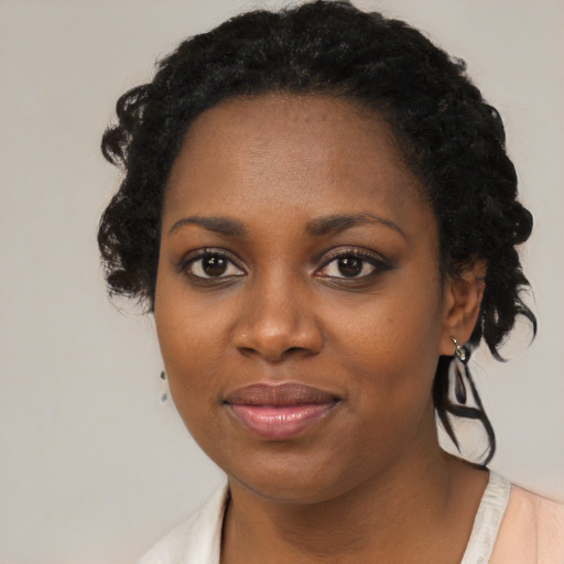 Joyful black young-adult female with medium  black hair and brown eyes