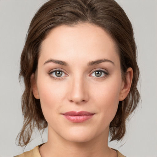 Joyful white young-adult female with medium  brown hair and green eyes