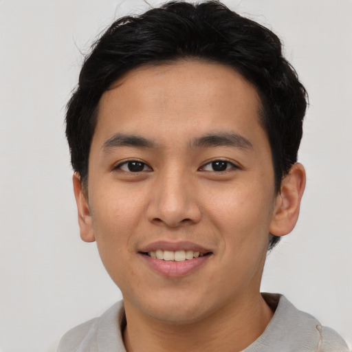 Joyful asian young-adult male with short  brown hair and brown eyes