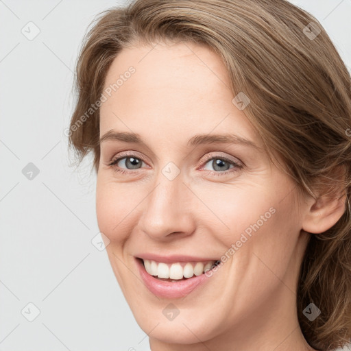 Joyful white young-adult female with long  brown hair and grey eyes