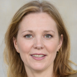 Joyful white adult female with medium  brown hair and blue eyes