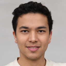 Joyful latino young-adult male with short  brown hair and brown eyes