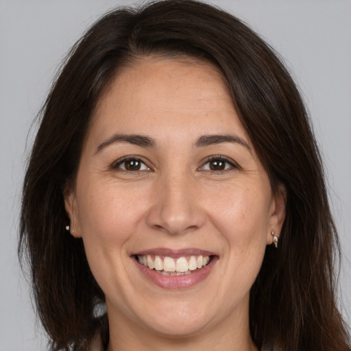 Joyful white adult female with long  brown hair and brown eyes