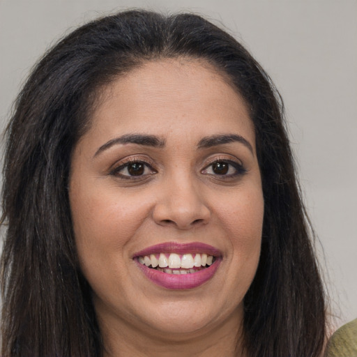 Joyful latino young-adult female with long  brown hair and brown eyes