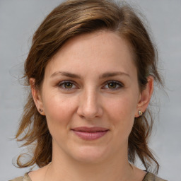 Joyful white young-adult female with medium  brown hair and blue eyes