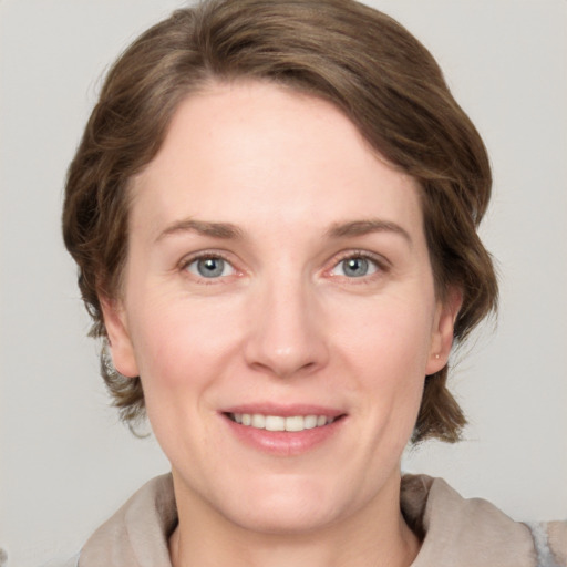 Joyful white adult female with medium  brown hair and grey eyes