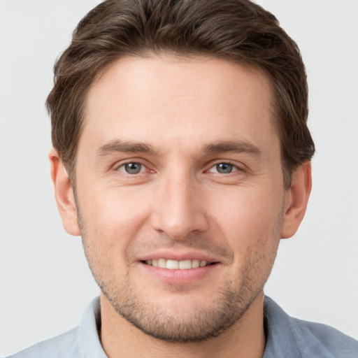 Joyful white young-adult male with short  brown hair and grey eyes