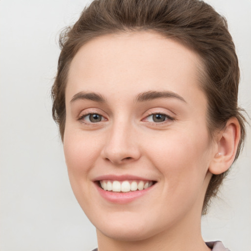 Joyful white young-adult female with medium  brown hair and green eyes