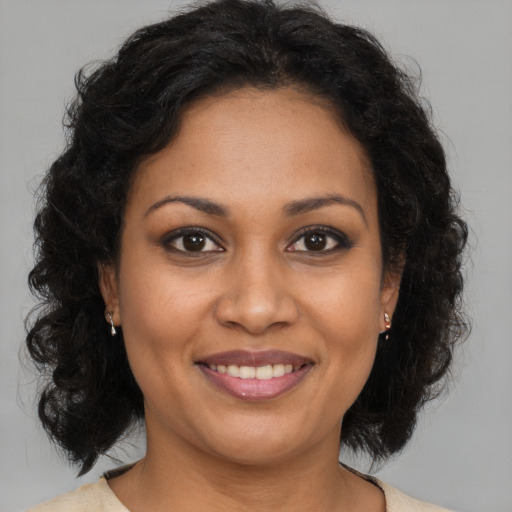 Joyful black adult female with medium  brown hair and brown eyes