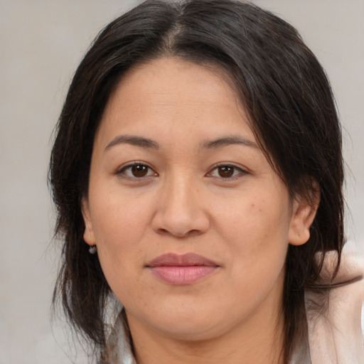 Joyful asian adult female with medium  brown hair and brown eyes