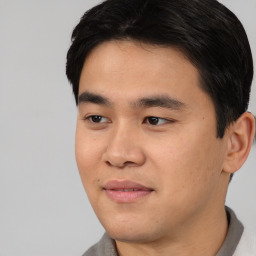 Joyful asian young-adult male with short  black hair and brown eyes