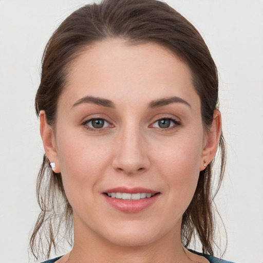 Joyful white young-adult female with medium  brown hair and grey eyes