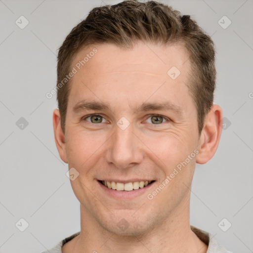 Joyful white young-adult male with short  brown hair and grey eyes