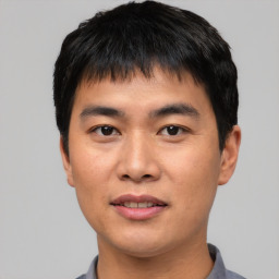 Joyful asian young-adult male with short  black hair and brown eyes