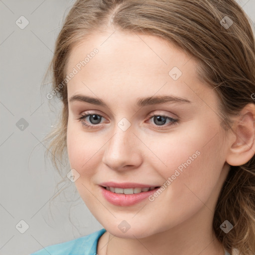 Joyful white young-adult female with medium  brown hair and blue eyes