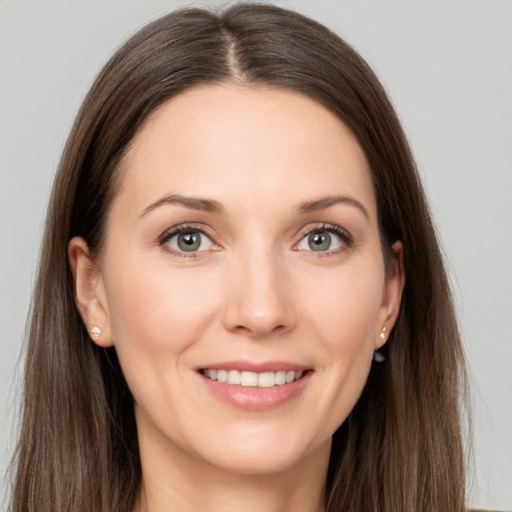 Joyful white young-adult female with long  brown hair and grey eyes