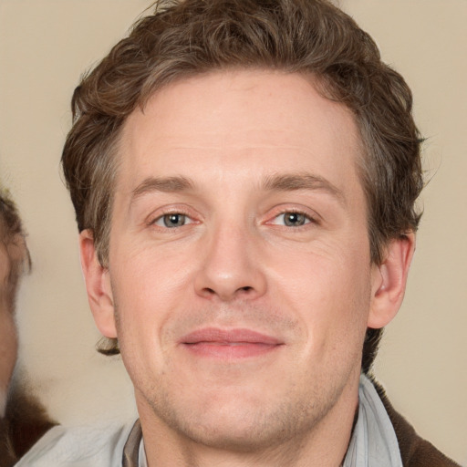 Joyful white adult male with short  brown hair and grey eyes