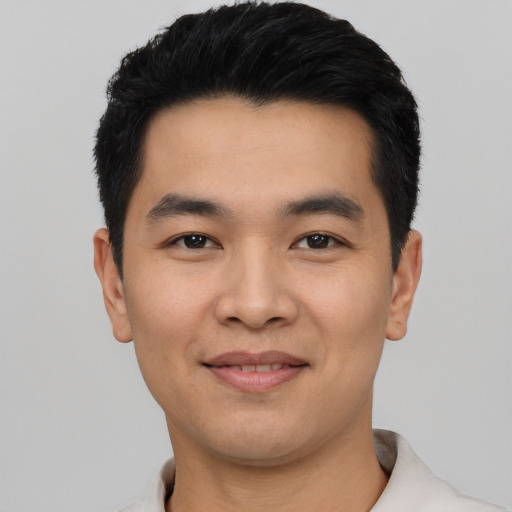 Joyful asian young-adult male with short  black hair and brown eyes