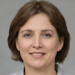 Joyful white adult female with medium  brown hair and grey eyes