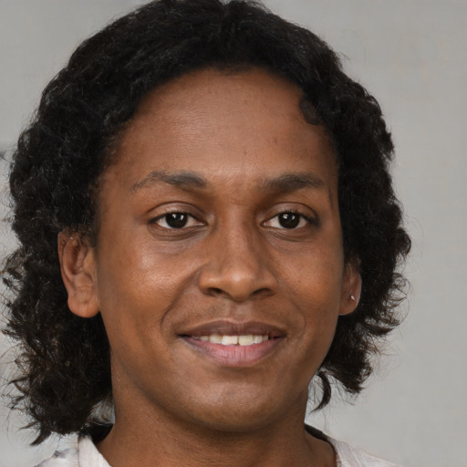 Joyful black adult female with medium  brown hair and brown eyes
