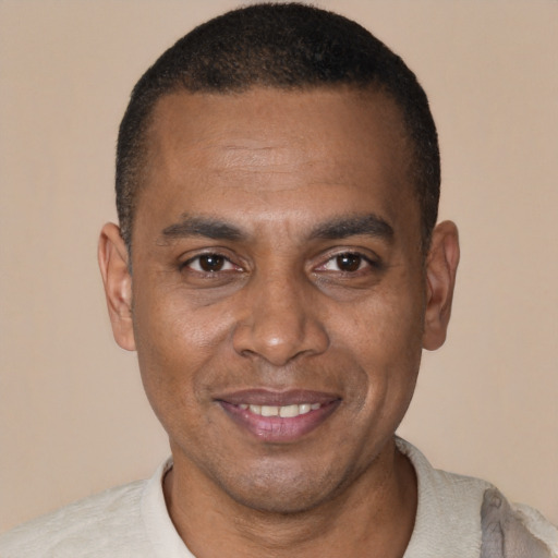 Joyful black young-adult male with short  brown hair and brown eyes