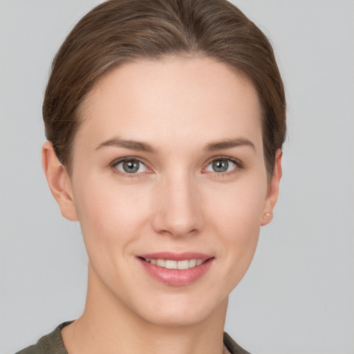 Joyful white young-adult female with short  brown hair and grey eyes