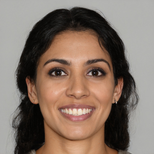 Joyful latino young-adult female with medium  brown hair and brown eyes