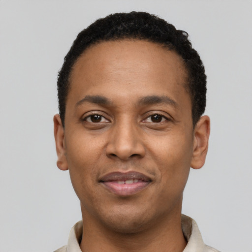 Joyful black young-adult male with short  black hair and brown eyes