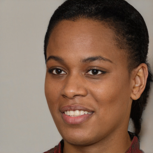 Joyful black young-adult female with long  brown hair and brown eyes