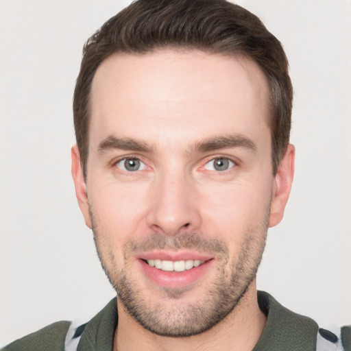 Joyful white young-adult male with short  brown hair and grey eyes