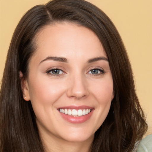 Joyful white young-adult female with long  brown hair and brown eyes