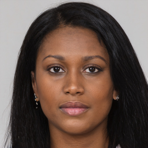 Joyful black young-adult female with long  black hair and brown eyes