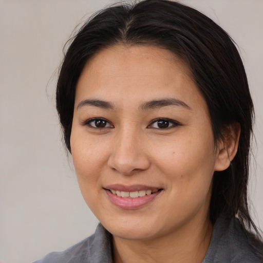 Joyful asian young-adult female with medium  brown hair and brown eyes