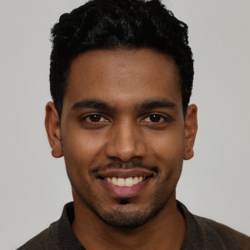 Joyful black young-adult male with short  black hair and brown eyes