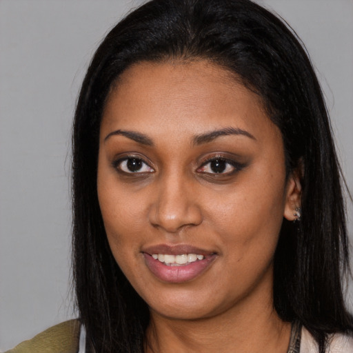 Joyful black young-adult female with long  black hair and brown eyes