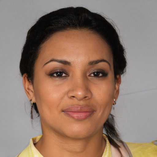 Joyful latino adult female with medium  brown hair and brown eyes