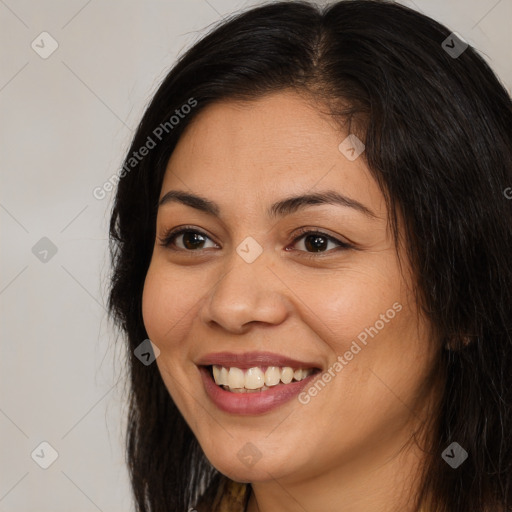 Joyful latino young-adult female with long  brown hair and brown eyes