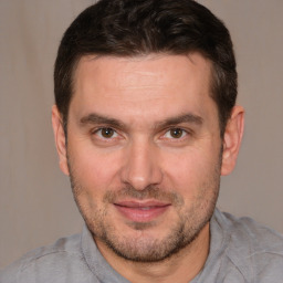 Joyful white adult male with short  brown hair and brown eyes